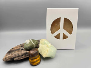 All natural plant based soap scented with vanilla and housed in a white box with a peace sign cut out surrounded by driftwood and crystals.