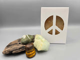 All natural plant based soap scented with vanilla and housed in a white box with a peace sign cut out surrounded by driftwood and crystals.